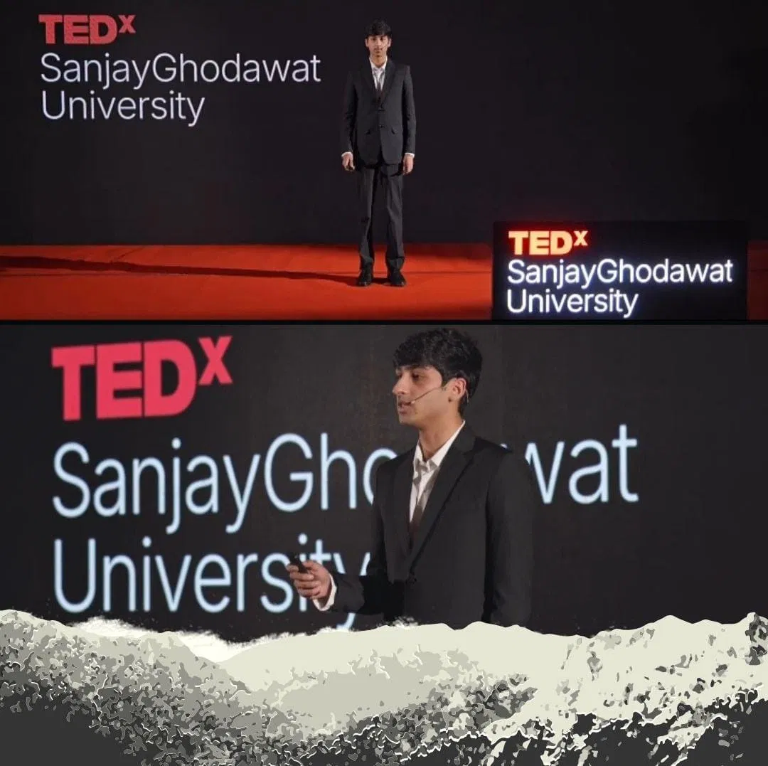Speaker on stage in suit, TEDx SGU