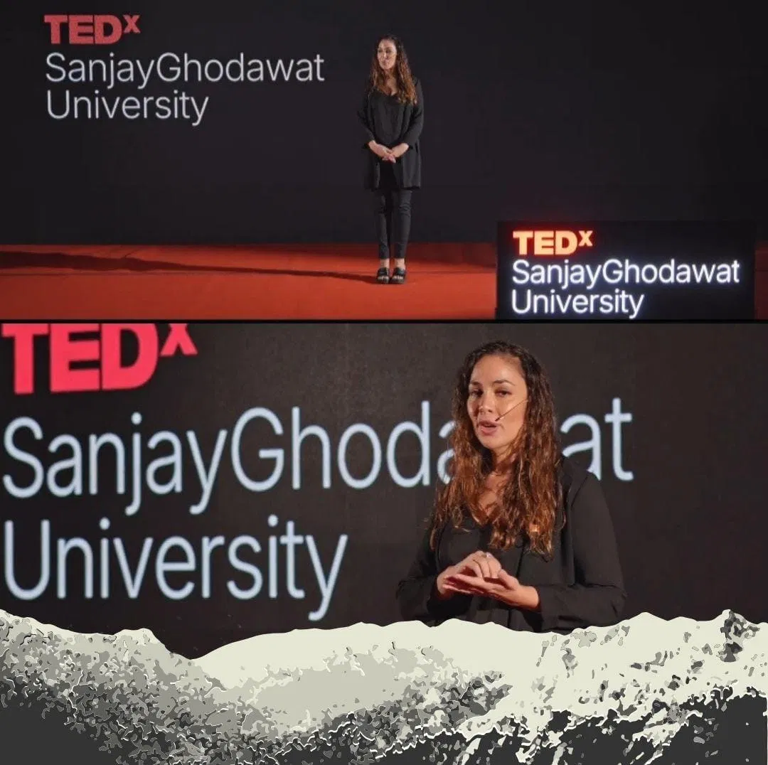 Speaker on stage, curly hair, TEDx SGU